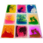 Kore Design - Carreaux de sol liquides - Couleurs assorties - Carrés - 12 po x 12 po x 0,2 po - Ensemble de 9-Dansez, jouez et apprenez : ces dalles sensorielles en forme de disque enfermées dans du liquide sont durables, résistantes aux déchirures et aux fuites, garantissant une résistance aux jeux, à la danse et aux sauts. Avec un dos antidérapant, elles restent bien en place pendant le jeu