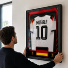 Frameworth - Coupe du Monde FIFA 2026 Officielle Allemagne Jamal Musiala Cadre Réplique de Maillot - 25,75 po x 33,75 po-Fabriqué au Canada par Frameworth Sports Marketing, fondée en 1992, produisant des souvenirs sportifs sous licence officielle.